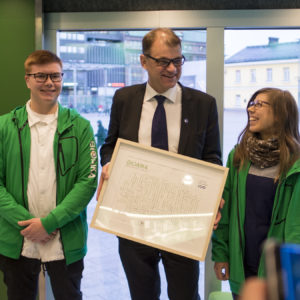 Bioaika-vision ojensivat pääministeri Juha Sipilälle Lapin lukiolaisten liiton tuleva puheenjohtaja Oskari Mattinen ja Lapin ammattikorkeakoulussa metsätalousinsinööriksi opiskeleva Maisa Hirvilammi. Kuva: Vilma Issakainen