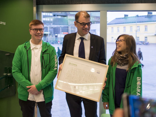 Bioaika-vision ojensivat pääministeri Juha Sipilälle Lapin lukiolaisten liiton tuleva puheenjohtaja Oskari Mattinen ja Lapin ammattikorkeakoulussa metsätalousinsinööriksi opiskeleva Maisa Hirvilammi. Kuva: Vilma Issakainen
