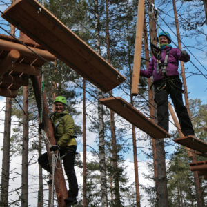 Anne Oksanen and Suvi Inkinen show how to do it. Before climbing, every customer is taught how to use the safety harness. Photo: Anna Kauppi