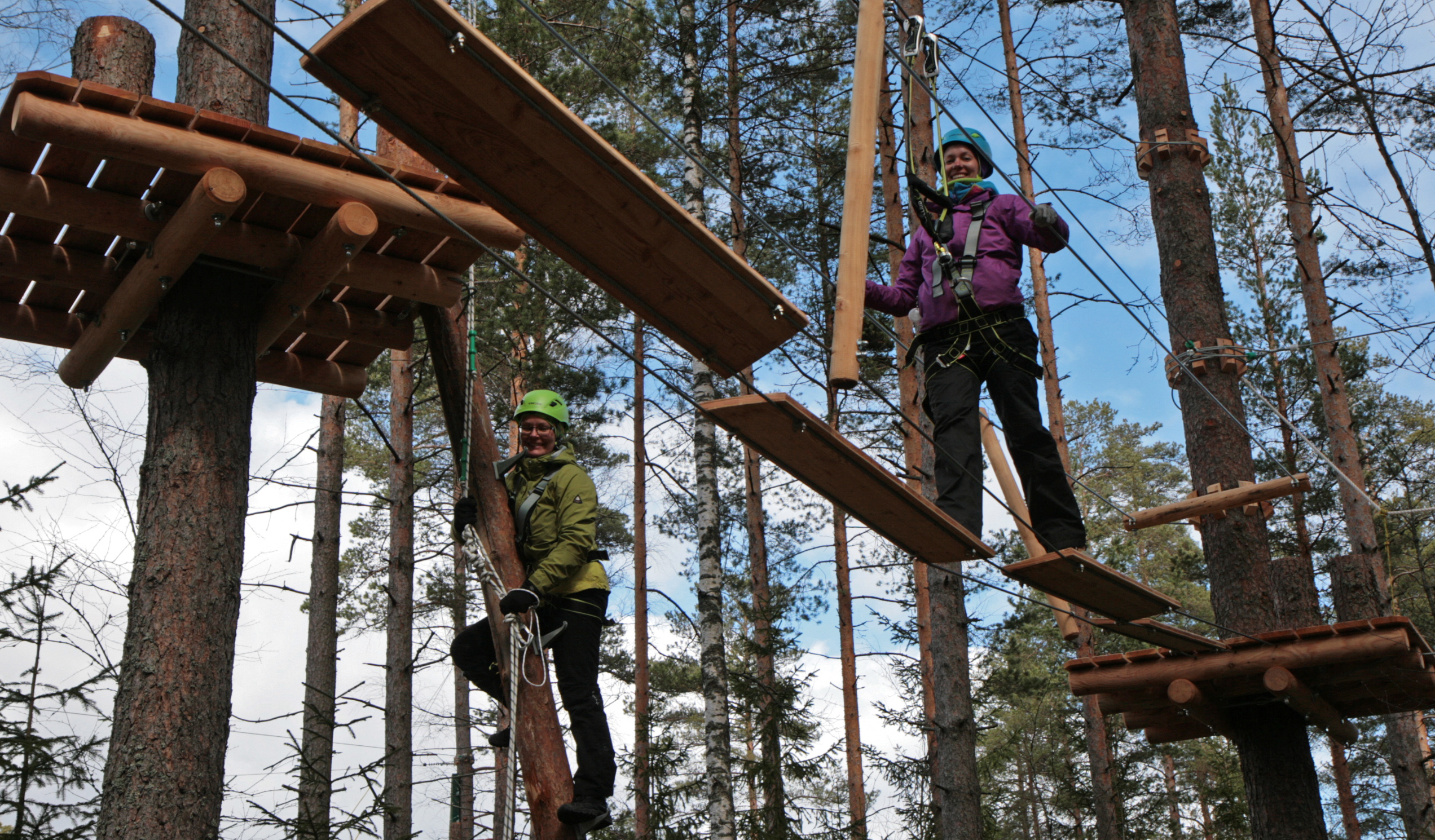 Anne Oksanen and Suvi Inkinen show how to do it. Before climbing, every customer is taught how to use the safety harness. Photo: Anna Kauppi