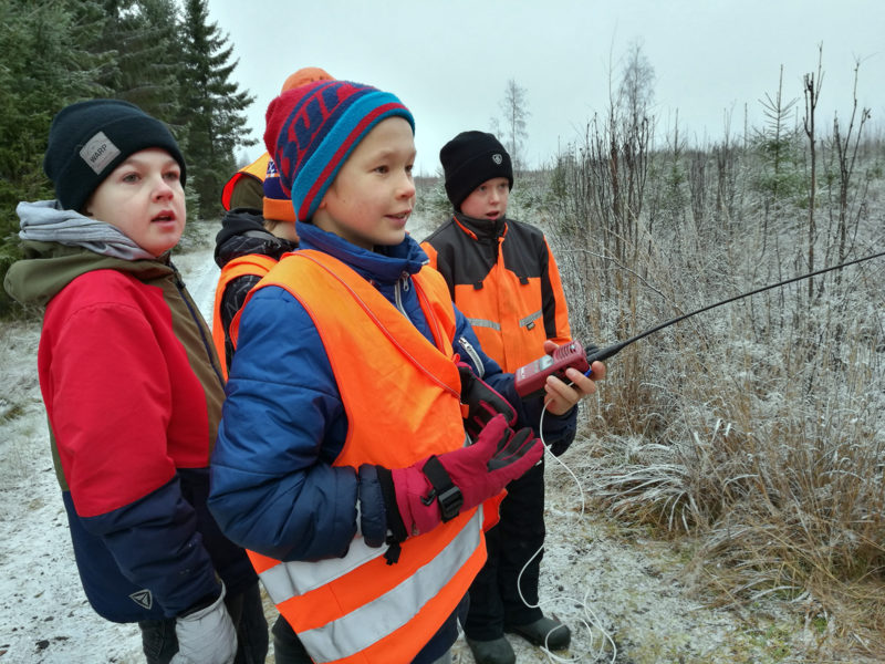 Oranssit vaatteet ja radiopuhelin ovat metsästäjän perusvarusteita, tietävät myös Tuomas, Oskari ja Samu. Kuva: Anna Kauppi