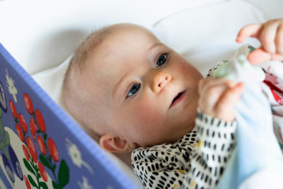 Vauva pötköttää äitiyspakkauslaatikossa. Kuva: Kela, Veikko Somerpuro