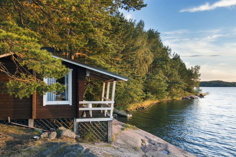 Mökki järven rannalla, metsän siimeksessä. Kuva: Shutterstock